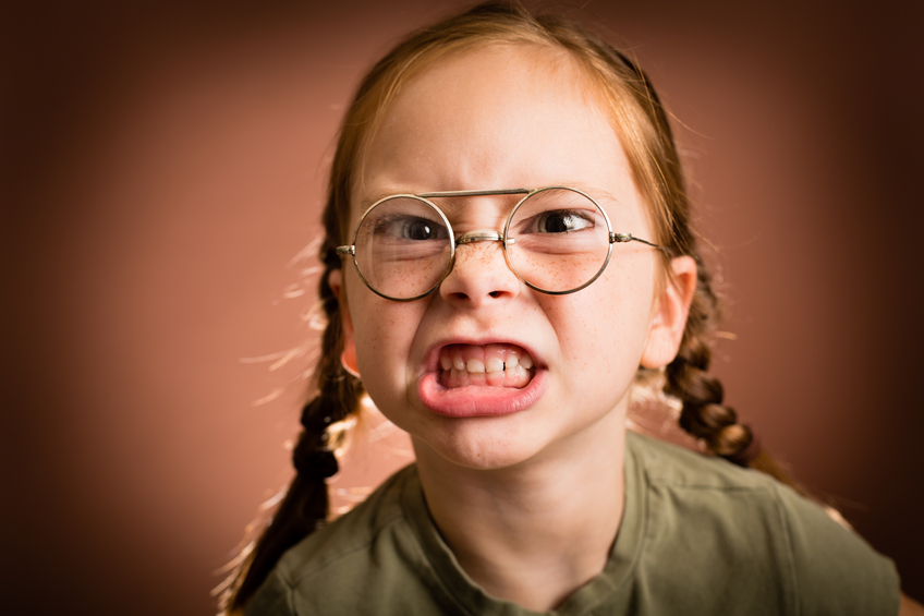 Little Girl Wearing Nerdy Glasses Making a Mean Face.